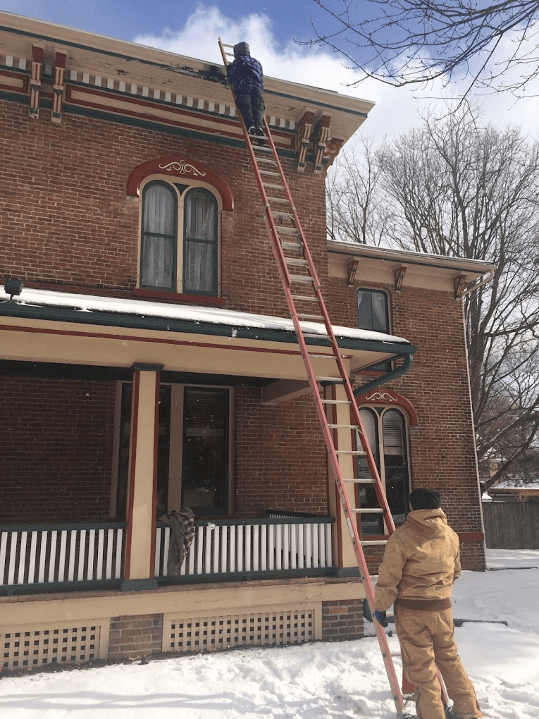 workers repairing roof and attic damage caused by wildlife infestation